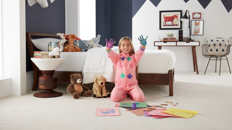 Little girl on cozy white carpet floor